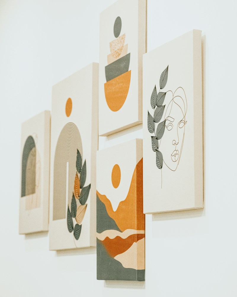 Group of abstract paintings on a wall in warm tones