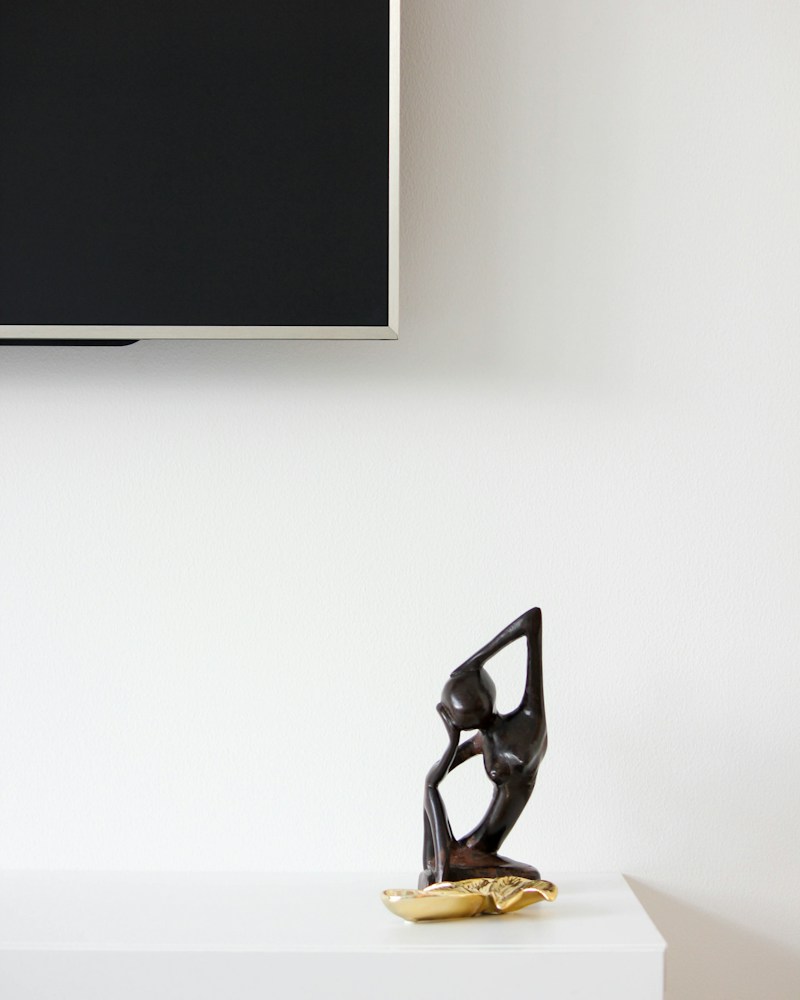 Handcrafted wooden sculpture on a shelf styled with décor objects