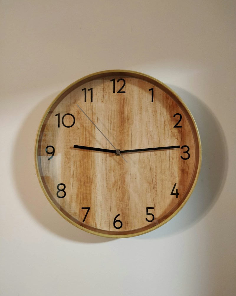 Warm-toned wooden round wall clock at ten o'clock