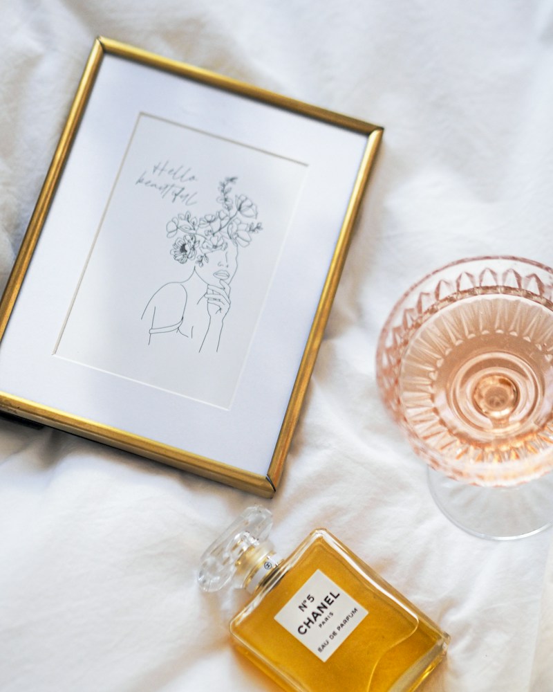 Framed illustrated art print styled on a shelf with a perfume bottle