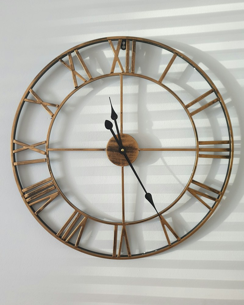 Round brass-toned wall clock with a warm vintage finish