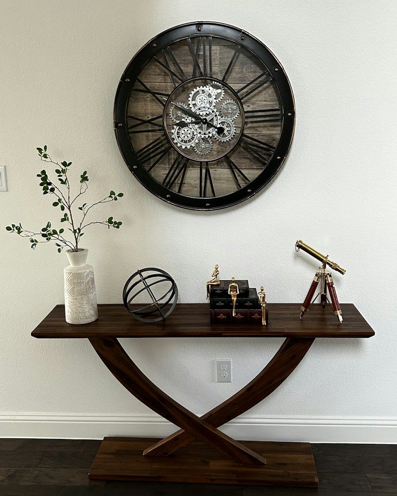 Artisan wall clock mounted above a wooden table in a warm interior